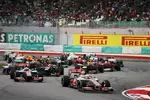 Foto zur News: Lewis Hamilton (McLaren) führt das Feld nach dem Start in Malaysia in die erste Kurve des Kurses in Sepang. Kurz darauf kam der große Regen...