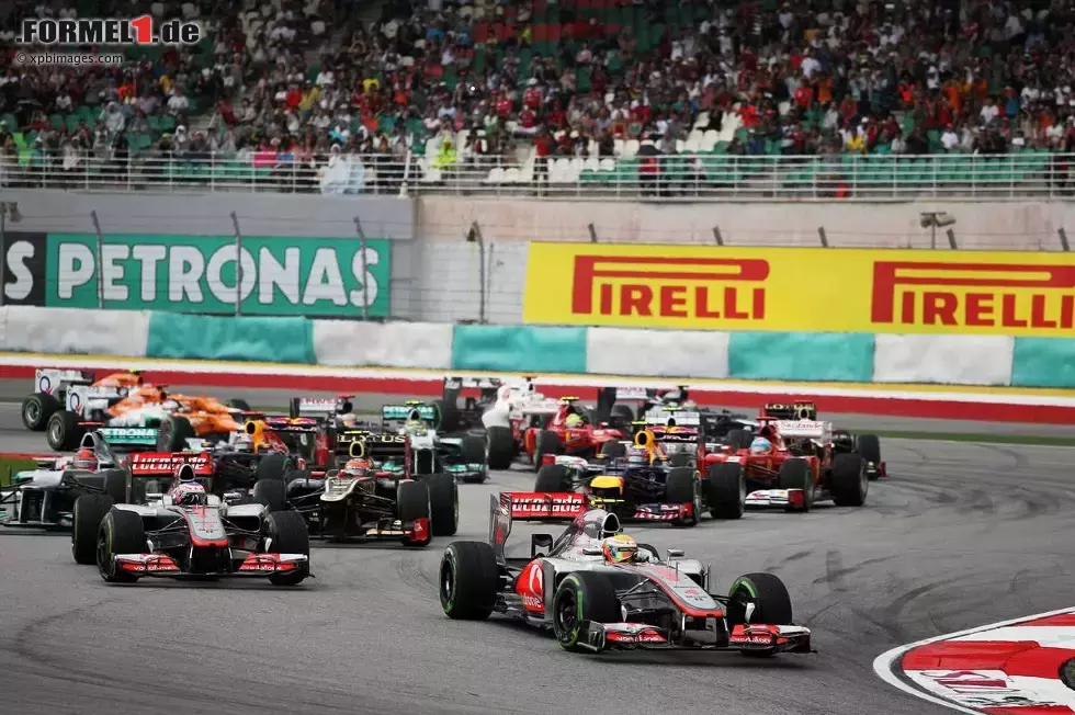 Foto zur News: Lewis Hamilton (McLaren) führt das Feld nach dem Start in Malaysia in die erste Kurve des Kurses in Sepang. Kurz darauf kam der große Regen...