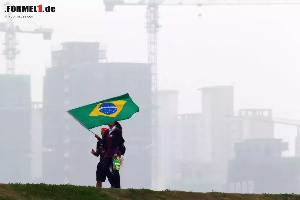 Foto zur News: Zwei Fans mit brasilianischer Flagge, im Hintergrund wächst Schanghai an die Strecke heran.