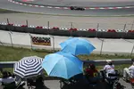 Foto zur News: Kein Regen in Spanien in Sicht, aber Schutz vor der Sonne bietet auch ein Regenschirm. Auf der Strecke zieht Kimi Räikkönen (Lotus) seine Kreise.