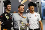 Foto zur News: Romain Grosjean (Lotus) und Jenson Button (McLaren) mit Paul Hembery (Pirelli)