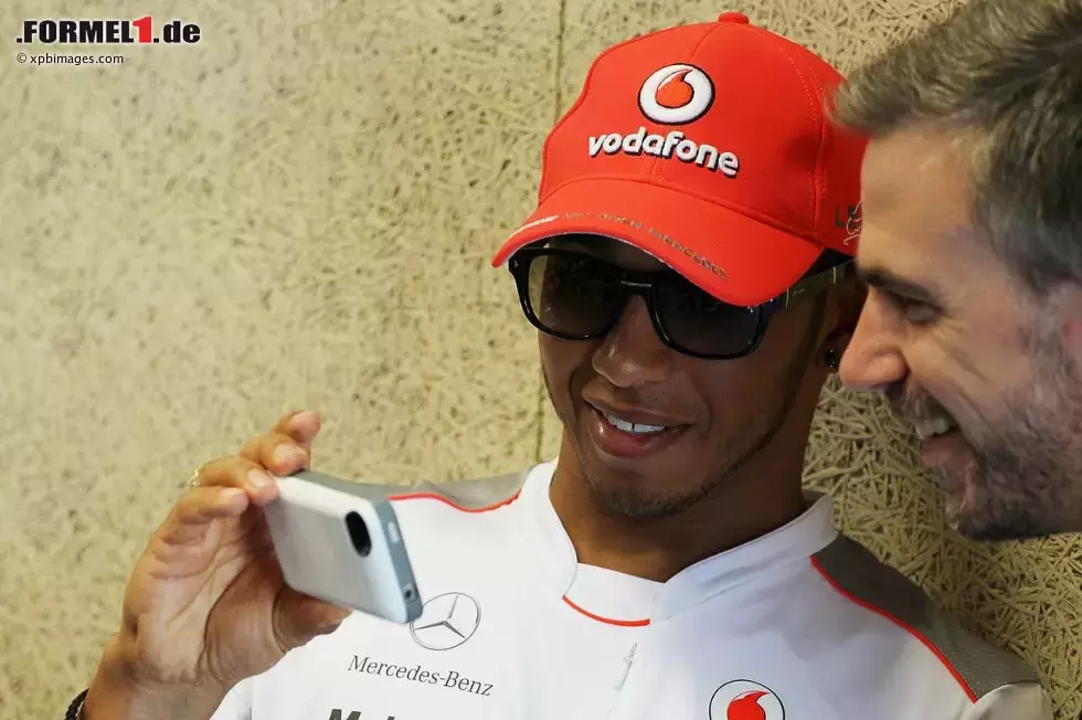 Foto zur News: Lewis Hamilton (McLaren) zeigt Pressesprecher Steve Cooper seine neuesten Handyfotos