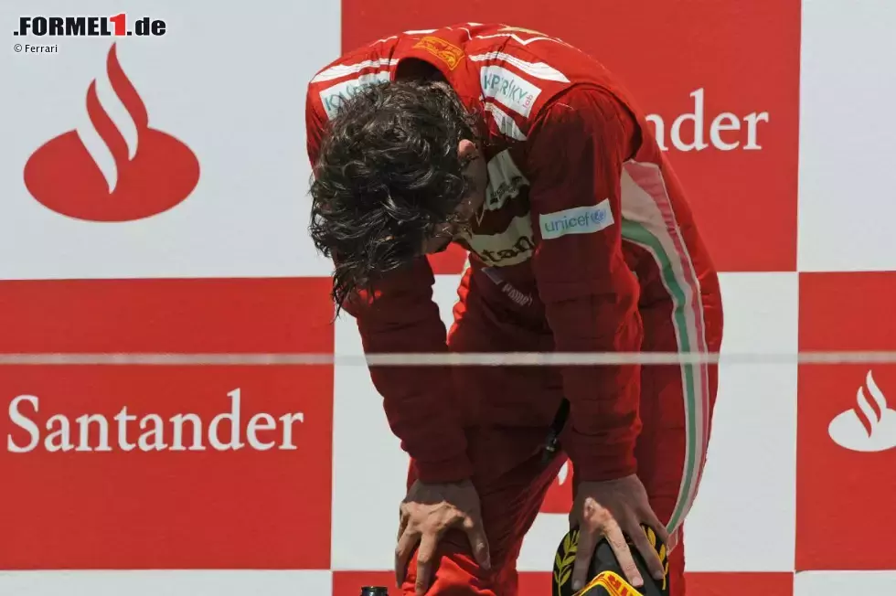 Foto zur News: Von seinen Emotionen überwältigt: Fernando Alonso (Ferrari) klappt bei der spanischen Hymne fast zusammen