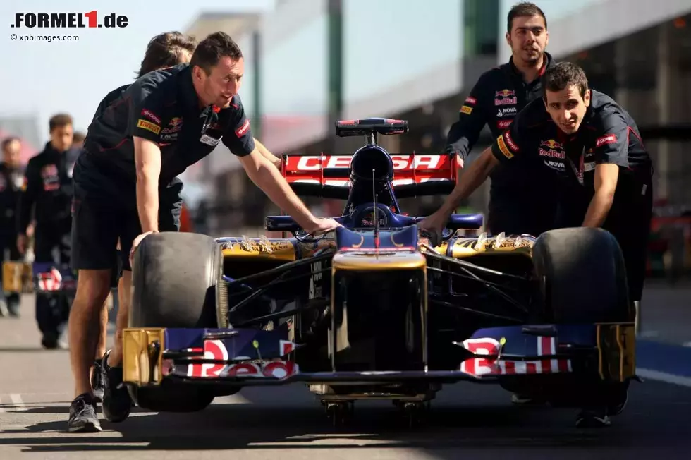 Foto zur News: Mechaniker schieben einen Toro Rosso durch die Boxengasse