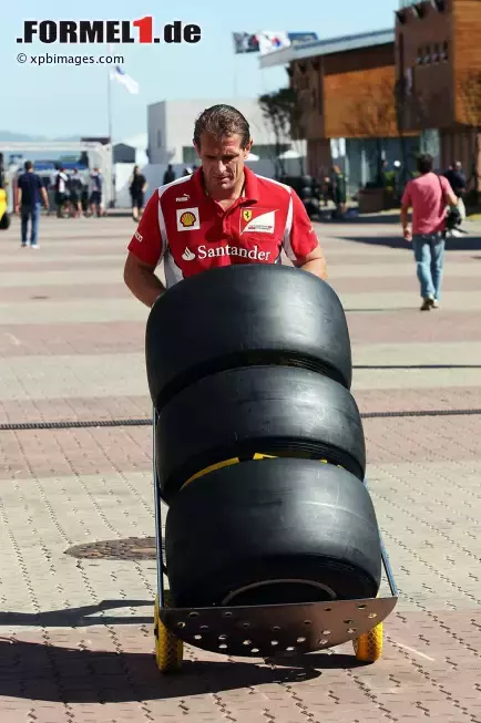 Foto zur News: Ferrari-Mechaniker mit drei Pirelli-Reifen