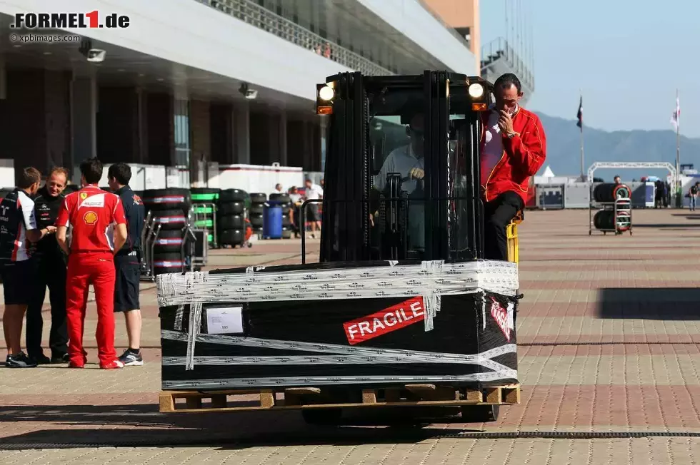 Foto zur News: Kisten mit Equipment werden durch die Boxengasse gekarrt