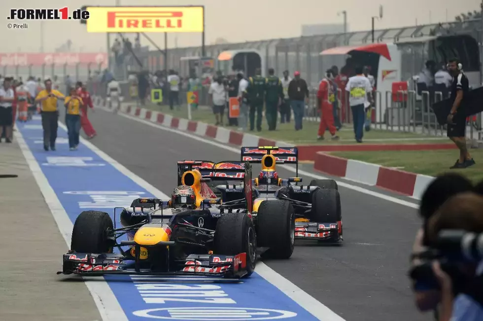 Foto zur News: Sebastian Vettel (Red Bull) wird von Mark Webber (Red Bull) auf seine Position im Parc ferme geschoben