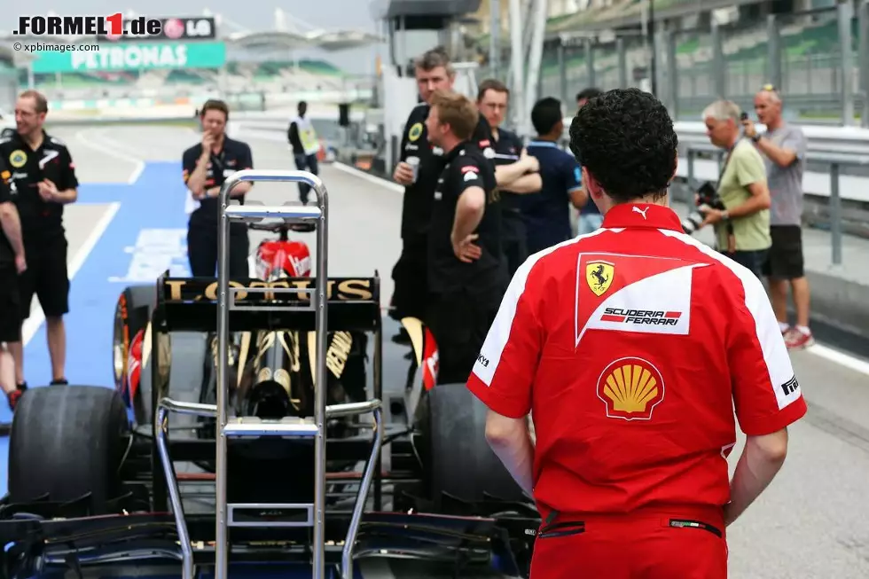 Foto zur News: Ferrari-Mechaniker schaut sich den Lotus E21 an