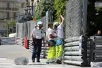 Foto zur News: Streckenposten nehmen die letzten Arbeiten an der Strecke vor