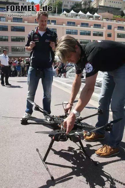 Foto zur News: Sebastian Vettel (Red Bull) bewundert einen ferngesteuerten Kamera-Helikopter