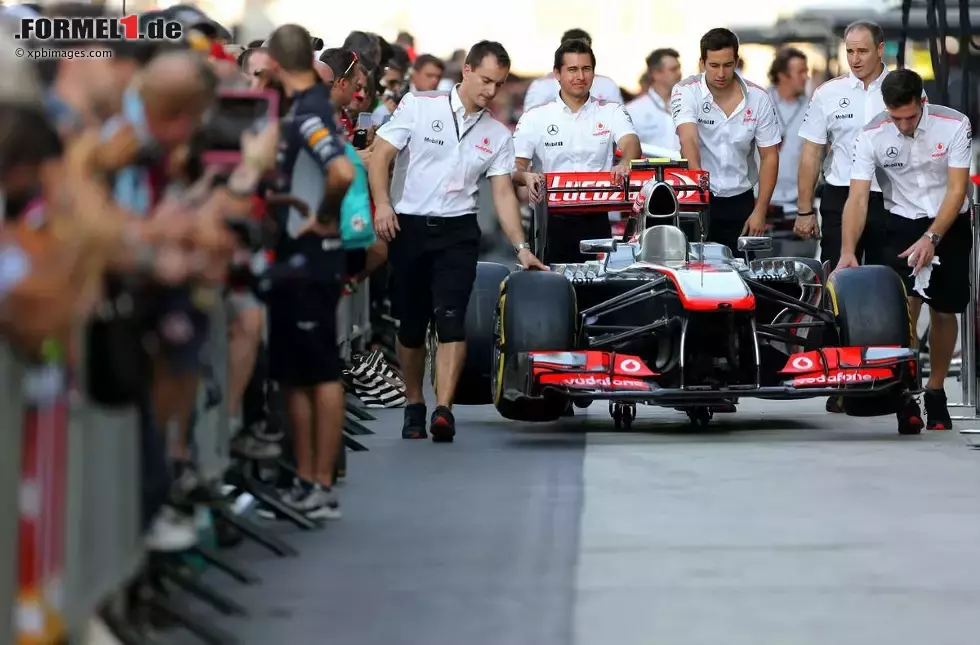 Foto zur News: McLaren-Mechaniker schieben das Auto durch die Boxengasse