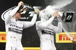 Foto zur News: Nico Rosberg (Mercedes) verpasst Lewis Hamilton (Mercedes) eine kräftige Champagner-Dusche