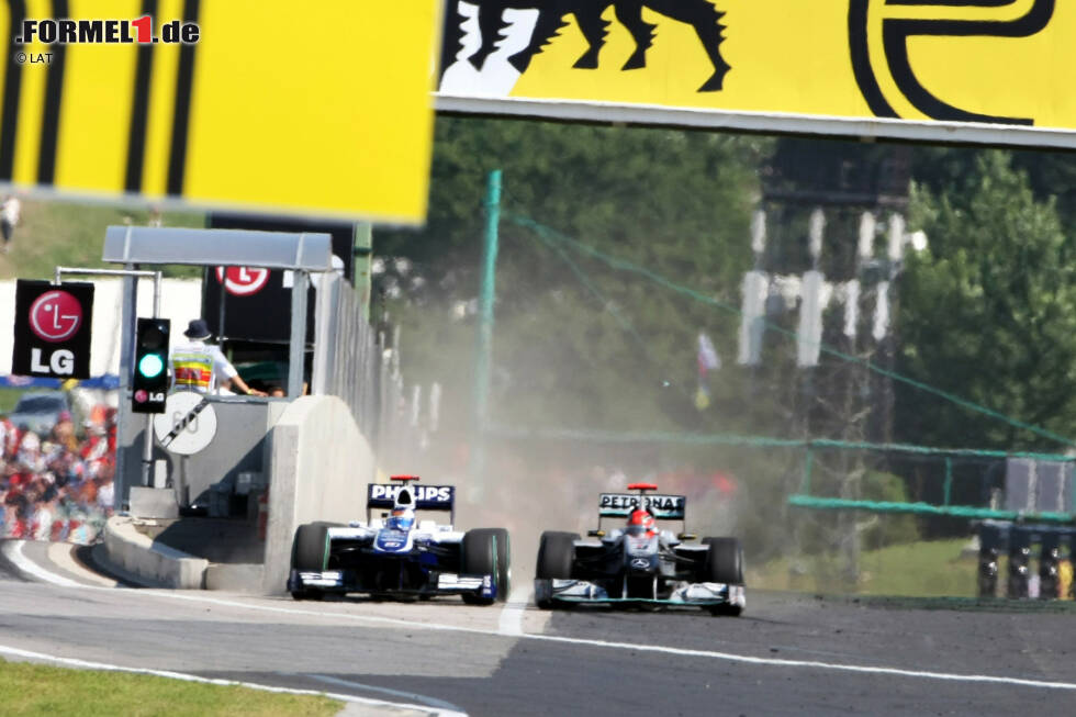 Foto zur News: Der Williams von Barrichello zwängt sich bei mehr als 250 km/h durch die enge Lücke zwischen Boxenmauer und Schumachers Mercedes.