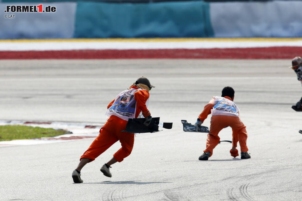 Foto zur News: Aber wenn&#039;s ernst wird, geht&#039;s voll zur Sache! Mit inzwischen 16 Grands Prix Erfahrung zählen die Streckenposten in Sepang längst nicht mehr zu den Amateuren der Formel 1, wie das in den Anfangsjahren der Fall war.