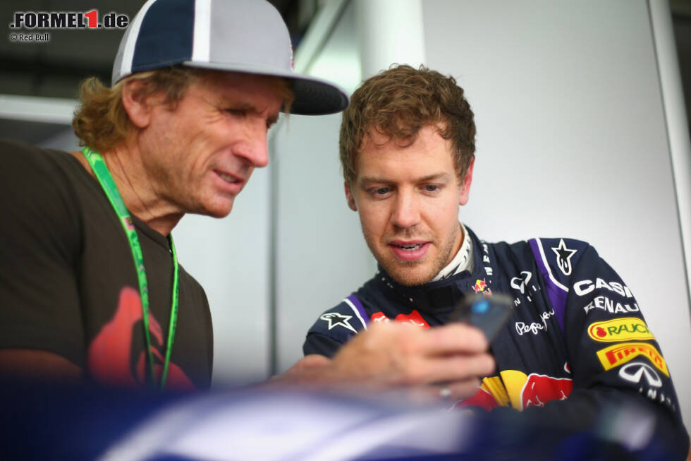 Foto zur News: Die Welt von Red Bull: Surfer-Legende Robbie Naish zeigt Sebastian Vettel seine neuesten Handyfotos. Man gehört ja zur gleichen Familie. Und wenn man ein echter &quot;Bulle&quot; ist, telefoniert man idealerweise auch noch mit dem Red-Bull-Mobiltarif. Jawohl, sowas gibt&#039;s inzwischen auch.