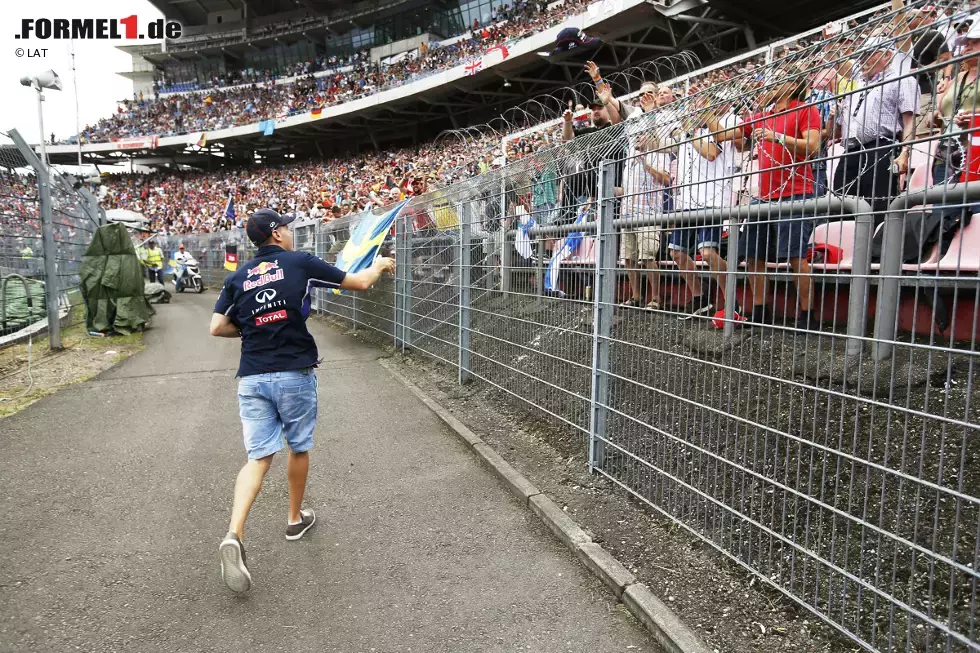 Foto zur News: Die, die da sind, sorgen aber für gute Stimmung. Zum Beispiel während der Fahrerparade, als Sebastian Vettel im Motodrom aus seinem Oldtimer springt und signierte Red-Bull-Kappen verteilt.