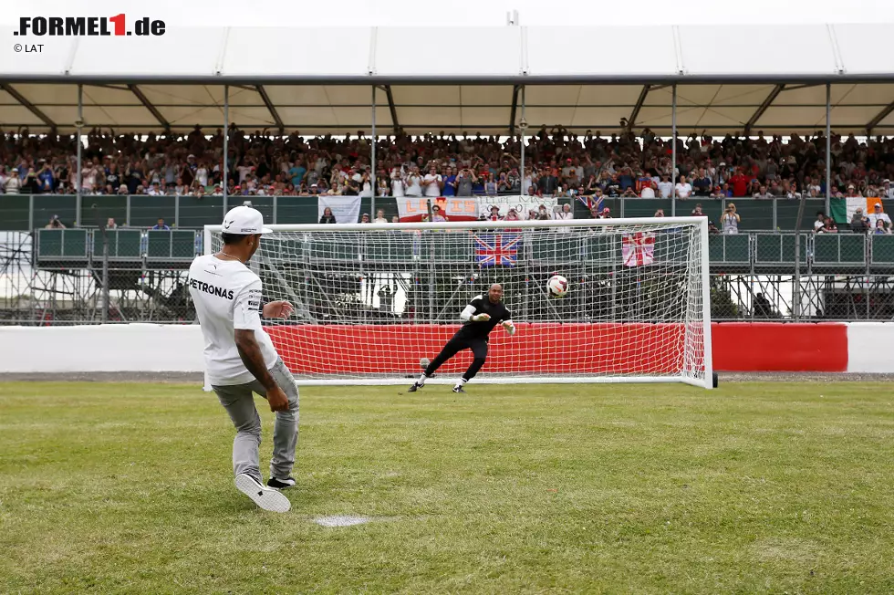 Foto zur News: Lewis Hamilton tritt stilsicher an und versenkt die Kugel im Netz, wenn auch nicht bei all seinen Versuchen. Organisiert wird der kleine Kick übrigens vom britischen Fernsehen - sehr zur Freude der Fans, die schon vor dem ersten Training enthusiastischer jubeln als auf jeder anderen Rennstrecke.