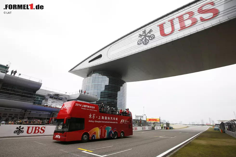 Foto zur News: Chinas Prunk erlebten die Piloten vom Bus, der sie bei der Fahrerparade am Sonntagmorgen um den Kurs kutschiert. Die gigantische Brücke über die Strecke ist nicht die einzige imposante Erscheinung auf der Anlage, die in einem Industriegebiet vor den Toren der 23-Millionen-Metropole gebaut wurde. Auch der Smog vermag zu beeindrucken, verschonte die Formel 1 aber am Wochenende.