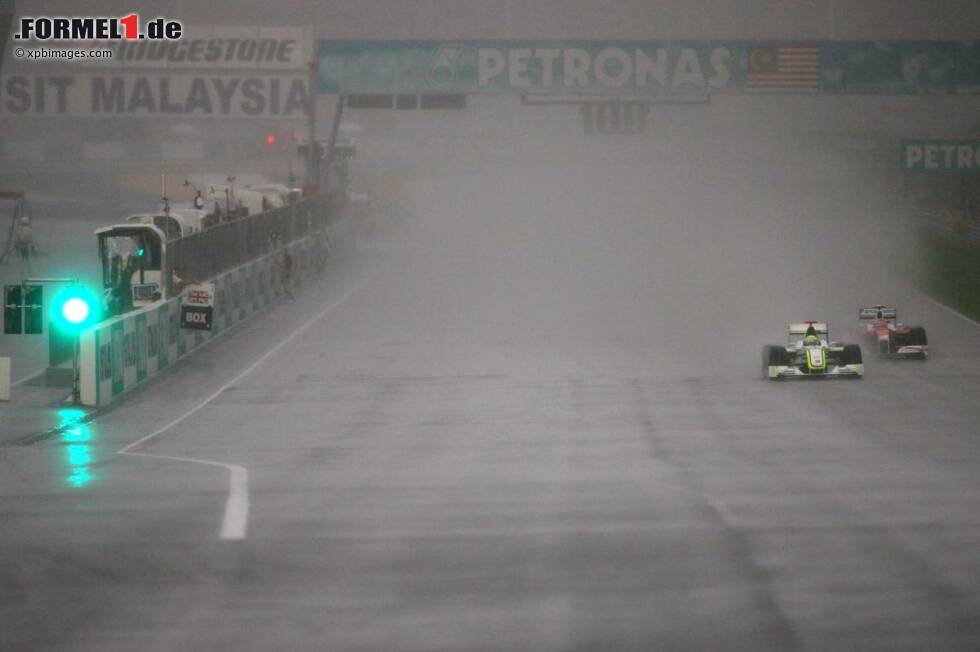 Foto zur News: Von der Pole-Position aus gestartet, fällt Jenson Button (Brawn) zunächst auf Platz vier zurück, doch als der große Regen kommt, führt er den Grand Prix von Malaysia 2009 längst wieder an. Wegen unfahrbarer Bedingungen muss das Rennen in Runde 33 vorläufig unterbrochen werden. Es führt Button vor dem richtigerweise mit Intermediates bestückten Timo Glock (Toyota) und Nick Heidfeld (BMW).