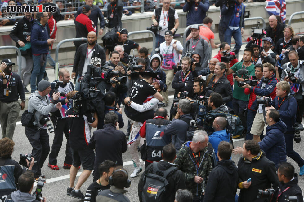 Foto zur News: ... oder einfach irgendjemandem um den Hals fallen. Und wenn man Lewis Hamilton heißt und gerade Formel-1-Weltmeister geworden ist, dann wird man beim Jubeln eben ständig von dutzenden Kameras begleitet.