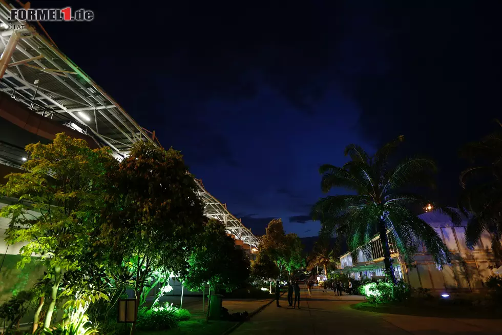 Foto zur News: Wenn es gerade mal nicht wie aus Eimern schüttet, kann Malaysia übrigens auch wunderschön sein. Tolle Atmosphäre abends im bunt beleuchteten Paddock...