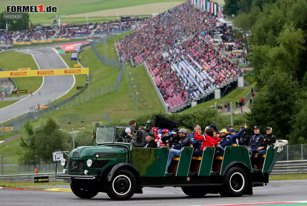 Foto zur News: Österreich ist eben anders: Fahrerparade nicht auf einem schmucklosen Truck, auch nicht mit Einzel-Oldtimern - sondern mit einem speziell angefehrtigten Fahrzeug, auf dem alle zusammensitzen. Österreichische Gemütlichkeit eben.