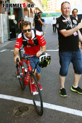 Foto zur News: Aber wer sein Fahrzeug wirklich liebt, der schiebt! Sebastian Vettel macht's am spartanischsten von allen, kommt statt motorisiert mit dem Fahrrad im Paddock an. Da bleibt auch Zeit, für die Fans ein paar Autogramme zu kritzeln, während er durchschnauft.