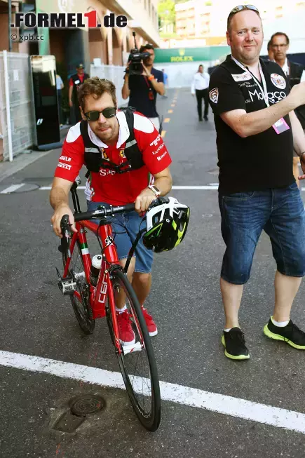 Foto zur News: Aber wer sein Fahrzeug wirklich liebt, der schiebt! Sebastian Vettel macht&#039;s am spartanischsten von allen, kommt statt motorisiert mit dem Fahrrad im Paddock an. Da bleibt auch Zeit, für die Fans ein paar Autogramme zu kritzeln, während er durchschnauft.