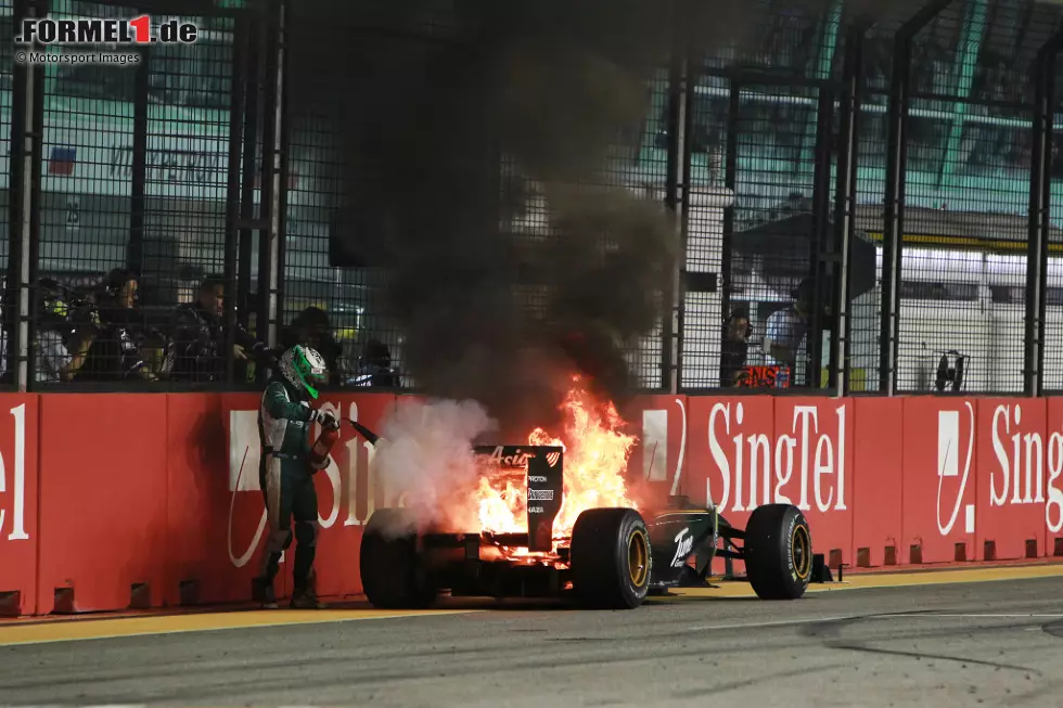 Foto zur News: Singapur 2010: Lotus-Fahrer Heikki Kovalainen kommt mit brennendem Auto vor der Boxengasse zu stehen. Dort holt er sich einen Feuerlöscher und löscht die Flammen selbst!