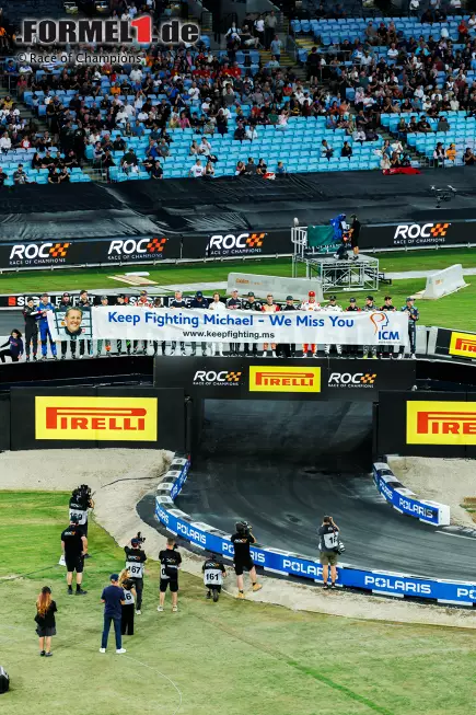 Foto zur News: Emotionen pur beim Race of Champions 2025: Im Accor Stadium in Sydney entrollten die 20 Teilnehmer ein Banner mit einem Gruß an Michael Schumacher: &quot;Keep Fighting Michael - We Miss You&quot; (&quot;Kämpf weiter, Michael - Wir vermissen dich&quot;).